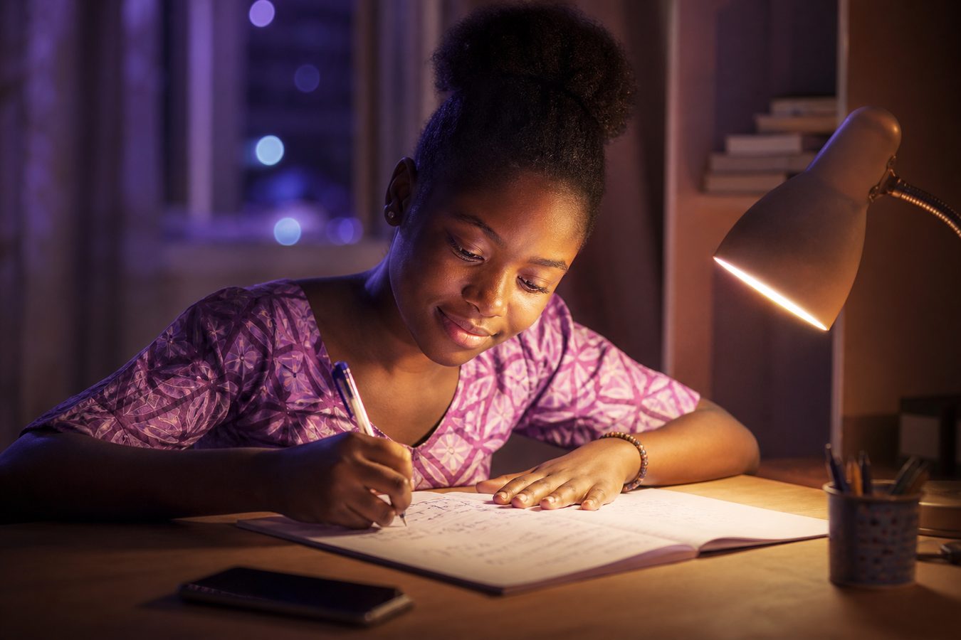 Un élève qui révise le soir, concentré sur ses exercices